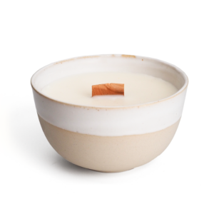 elfenbeinfarbene Kerze mit breitem Holzdoch, gegossen in sandfarbener Schale aus Steinzeug mit weißer Glaser im oberen Teil.