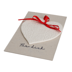 Porzellan-Anhänger in Herzform an rotem Band.